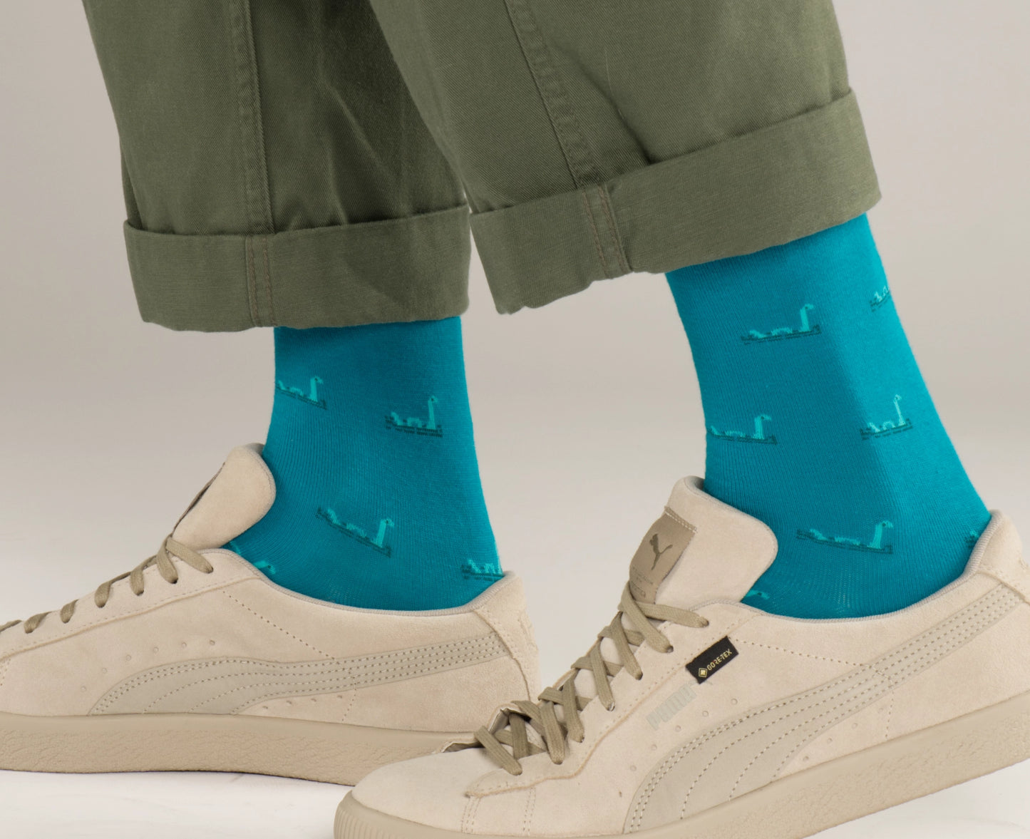 Loch ness monster socks with tartan studio label on model feet